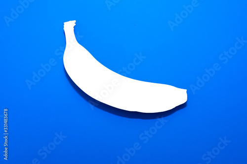 White silhouette of banana on a blue background.