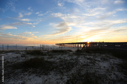 Panama city beach florida pier at sun down with beach silhouette and multi colored sky