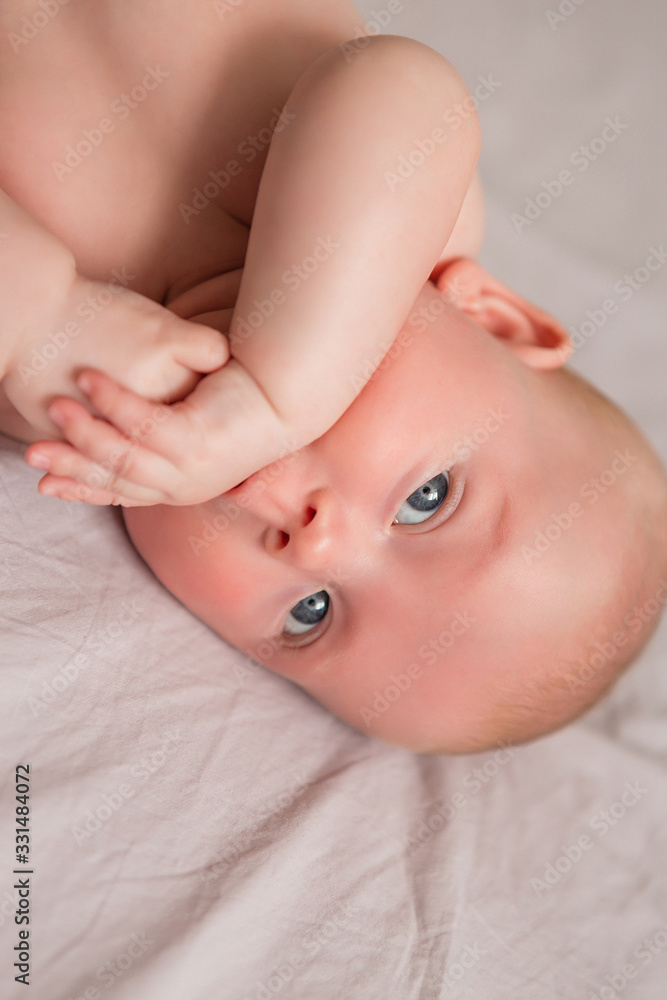 Happy 3 months old baby smiling, lying on white bed Happy 3 months old baby smiling, lying on white bed