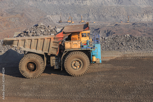 An old large mining truck loaded with iron ore in a quarry