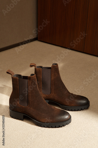 Custom made men's classic brown suede chelsey shoes in minimalist luxury tailor studio apartment