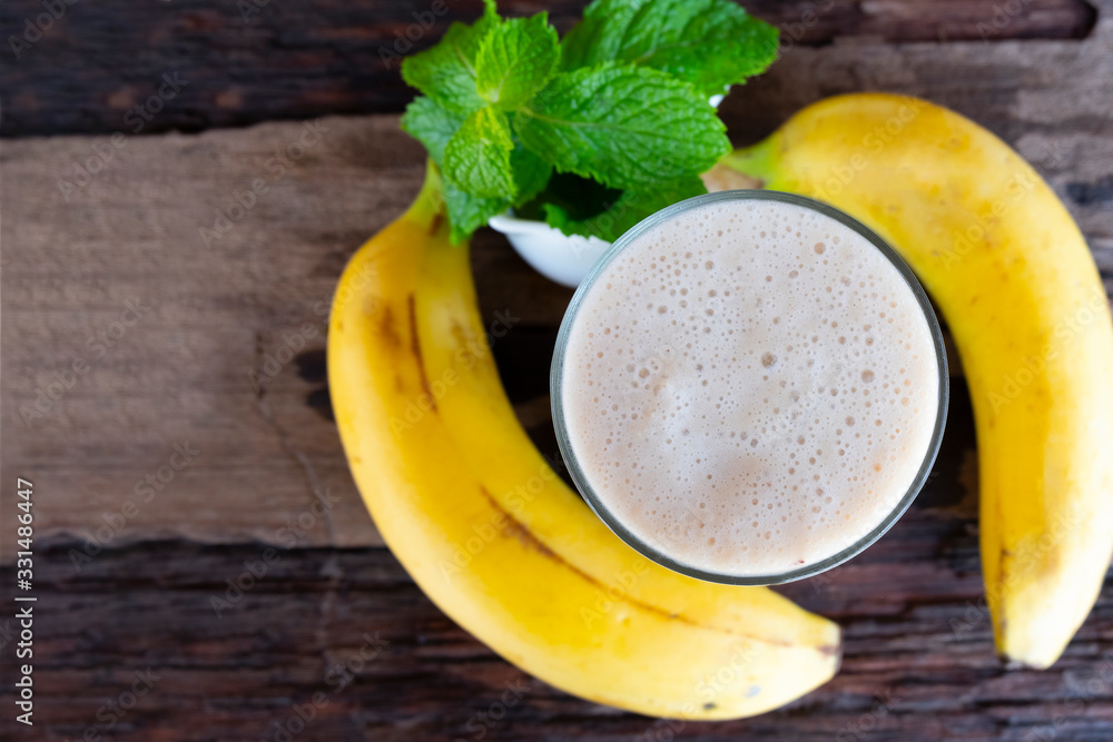 Banana fresh cocktail vanilla smoothies fruit juice beverage healthy the taste yummy in glass drink episode good morning on wooden background from the top view. Banana fresh cocktail vanilla smoothies fruit juice beverage healthy the taste yummy in glass drink episode good morning on wooden background from the top view.