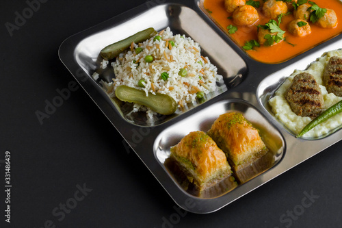 Photos Traditional Turkish meals,meatballs soup,rice,mashed potatoes,grilled meatball and two slices of baklava in stainless steel food tray
