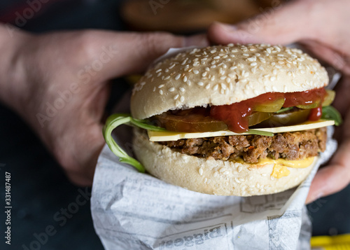 Closeup view of a vegan quorn burger held by man hands.