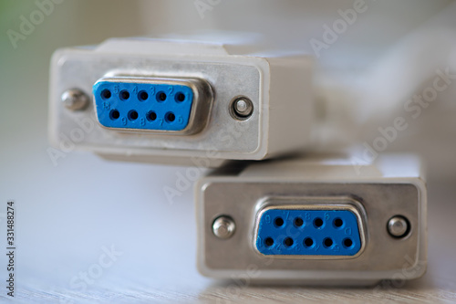 Close-up of a RS-232 serial port. Female to female extension cord on a wooden table.