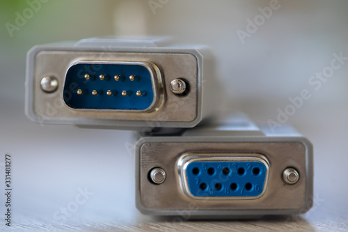 Close-up of a RS-232 serial port. Female to male extension cord on a wooden table.