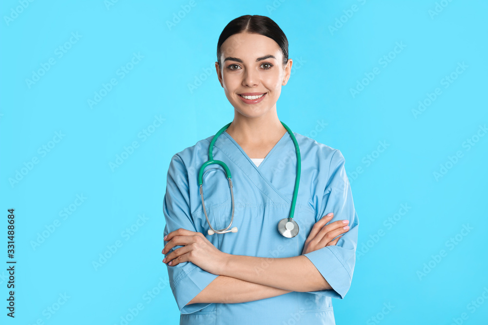 Portrait of young doctor with stethoscope on blue background Portrait of young doctor with stethoscope on blue background