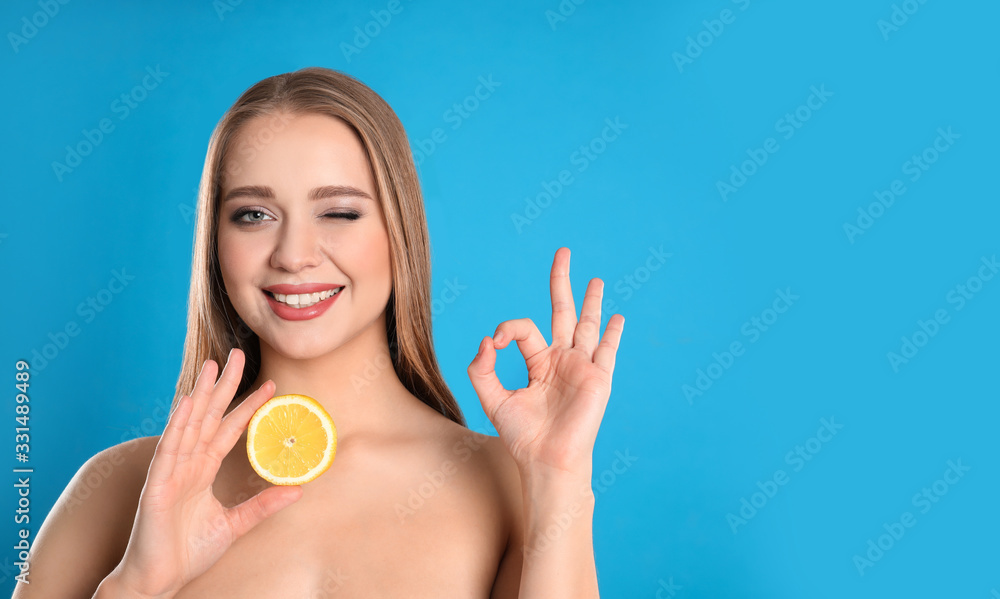 Young woman with cut lemon on blue background. Vitamin rich food Young woman with cut lemon on blue background. Vitamin rich food