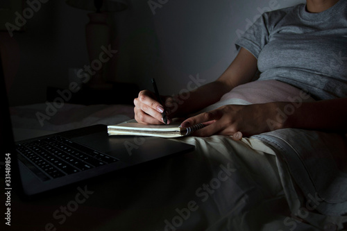 Woman in bed working late
