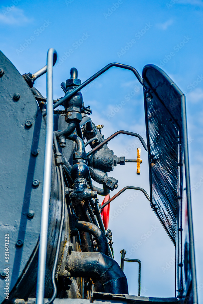 Tubes, pipes, valves, boxes, and handles of a vintage steam engine