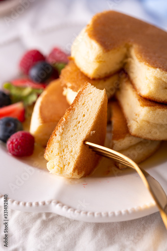 Trendy homemade Japanese fluffy pancakes for breakfast with berries, close up
