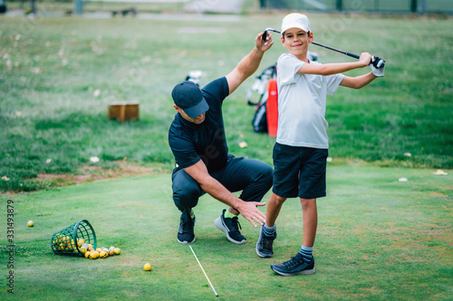 Golf Lesson. Golf Instructor Teaching Young Boy How to Swing