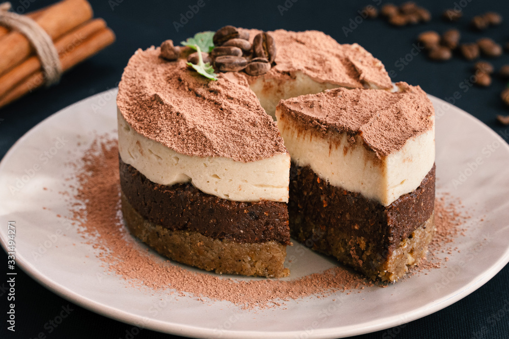 Tiramisu on a beige plate. Coffee with cinnamon. Raw dessert Tiramisu on a beige plate. Coffee with cinnamon. Raw dessert