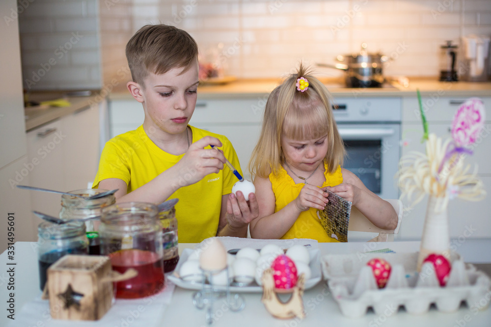 Kids draw easter eggs in the kitchen