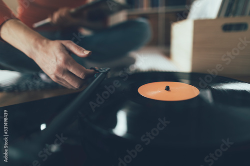 Close up of audiophile hand moving turntable tonearm over favorite song