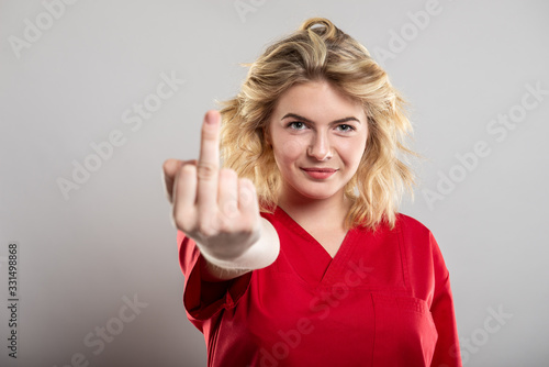 Wallpaper Mural Portrait of female nurse wearing red scrub showing obscene gesture Torontodigital.ca