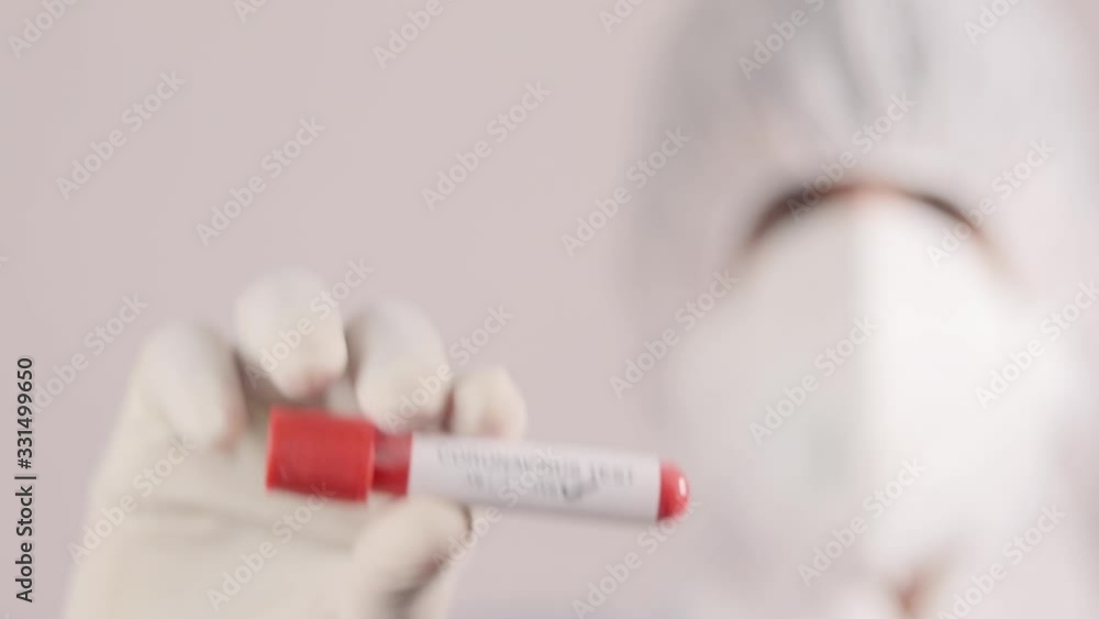 Doctor Hand holding positive blood sample Covid 19, coronavirus or sars cov 2 test tube in hand at hospital laboratory. Doctor Hand holding positive blood sample Covid 19, coronavirus or sars cov 2 test tube in hand at hospital laboratory.
