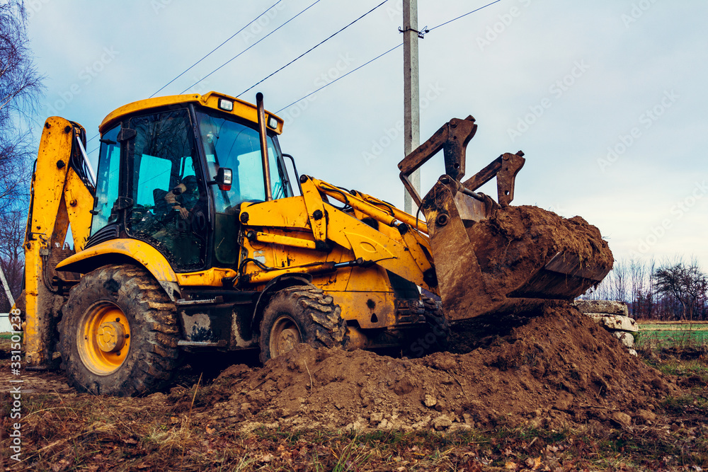 Closeup of a large bucket excavator digging the ground to set the road.  Stock Photo | Adobe Stock