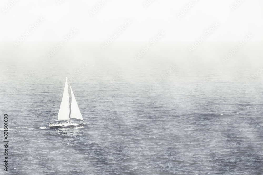 Single White Sail Boat on a Foggy Day and Calm Mediterranean Sea
