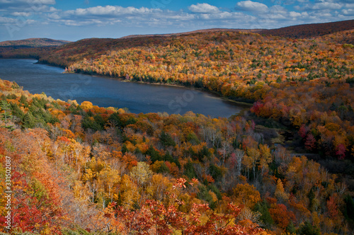 Shafts of sunlight play across the fall colors on the shore of Lake of the Clouds in the Porcupine Mountains Wilderness State Park, Michigan.