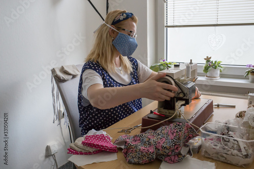 Woman sews a veil at home protecting a corona virus. Martin, Slavakia, Europe. 19. March 2020  photo