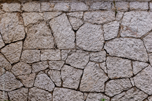 Texture of stone wall made of grey stones