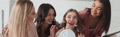Φωτογραφία Multicultural women with putting makeup with cosmetic brushes on bride, smiling