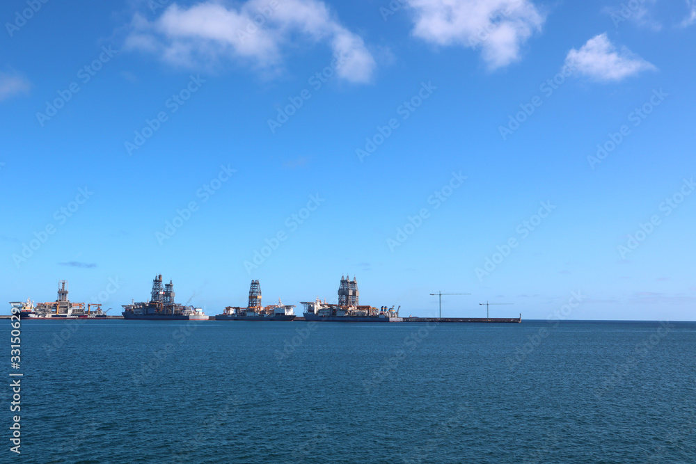 cargo ship going to a harbour in a calm sea with clear sky in summer