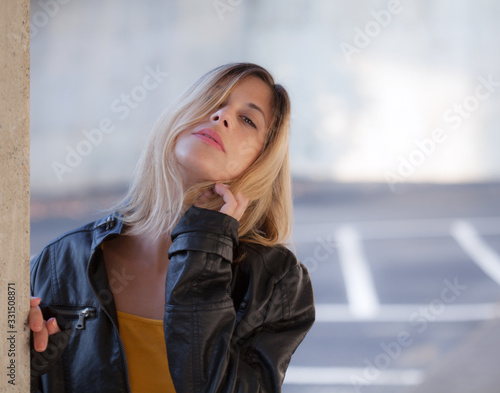Woman in Leather Jacket Outside Next to Pillar