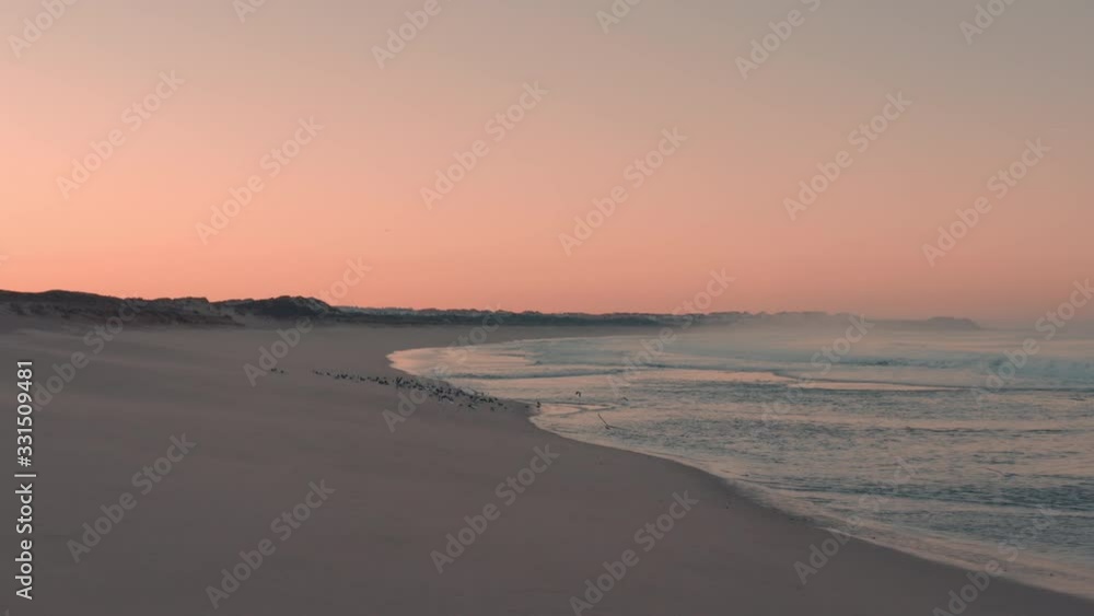 Amazing aerial view of a beach with sand on a sunset / sunrise. Birds / Seagulls are flying away. Beautiful nature and landscape. Perfect summer time. Amazing aerial view of a beach with sand on a sunset / sunrise. Birds / Seagulls are flying away. Beautiful nature and landscape. Perfect summer time.