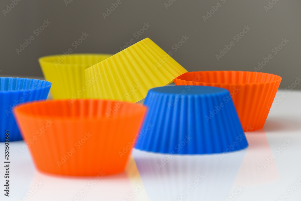 Colourful silicone muffin and cupcake reusable baking liners closeup on neutral background Colourful silicone muffin and cupcake reusable baking liners closeup on neutral background
