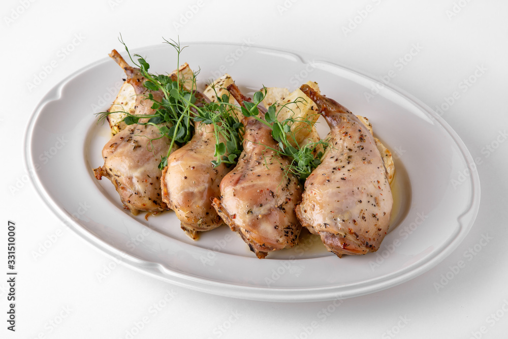 Baked tender juicy rabbit legs with celery. Banquet festive dishes. Gourmet restaurant menu. White background.
