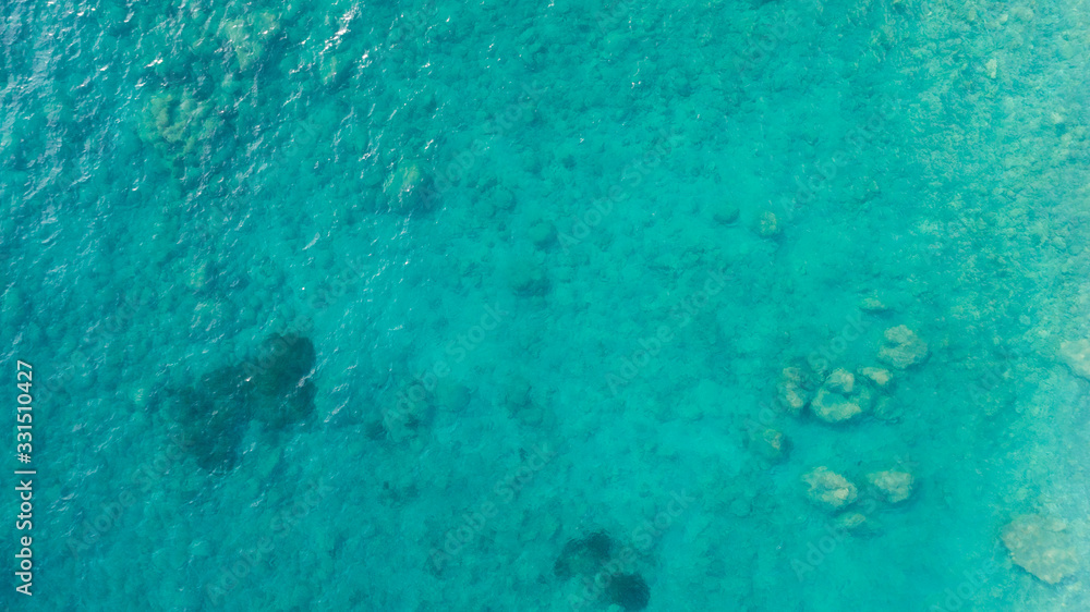 Aerial top down view photo of azure blue ocean waves showing beautiful bright and deep blue color from sea reef shallow water.
