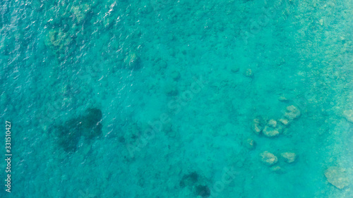 Aerial top down view photo of azure blue ocean waves showing beautiful bright and deep blue color from sea reef shallow water.