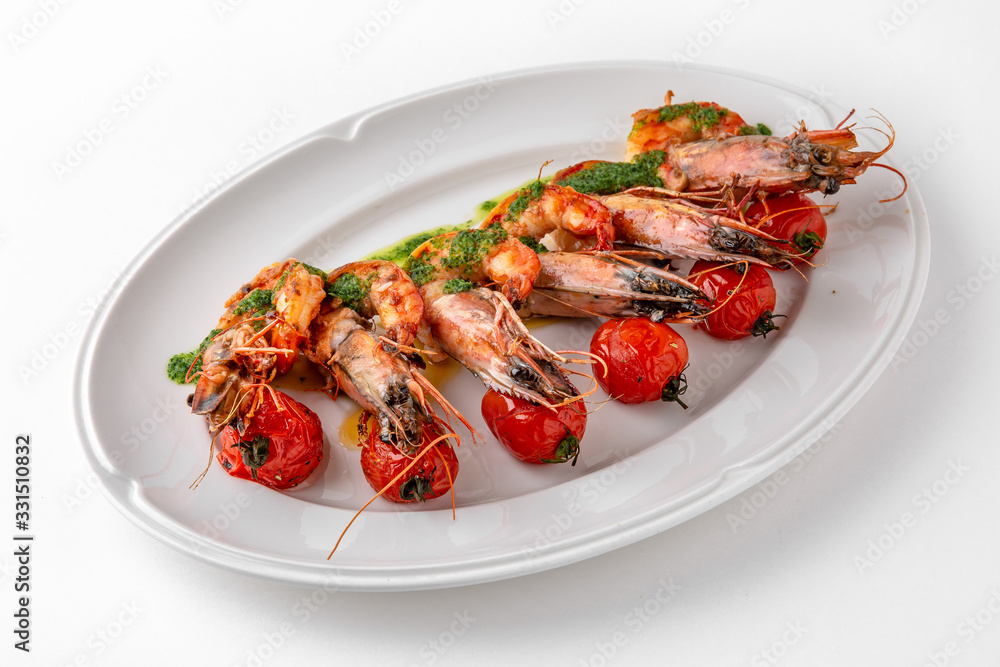 Luxurious seafood salad with grilled king prawns and baked cherry tomatoes. Banquet festive dishes. Gourmet restaurant menu. White background.