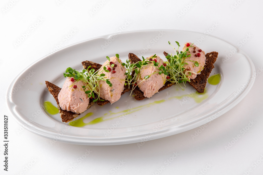Salmon paste with red allspice on rye flour crackers. Banquet festive dishes. Gourmet restaurant menu. White background. Salmon paste with red allspice on rye flour crackers. Banquet festive dishes. Gourmet restaurant menu. White background.