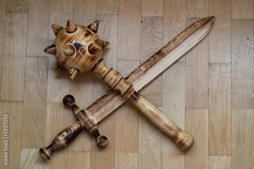 wooden Mace and sword lie on the floor, children's toys made of natural materials