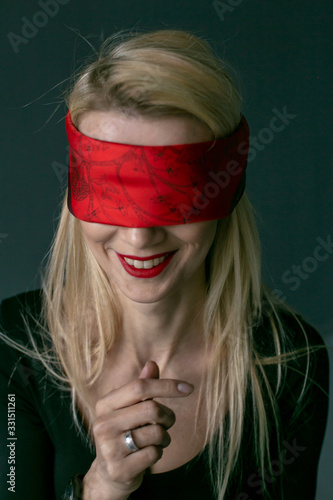 vertical close-up portrait of a beautiful laughing blonde with a blindfold