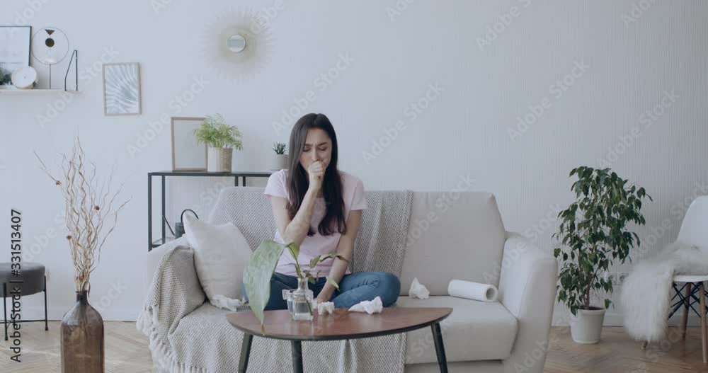 Young woman drinking water after cough at home Young woman drinking water after cough at home
