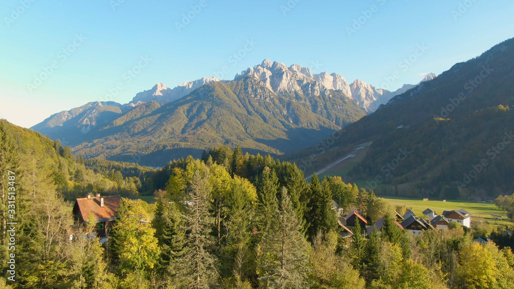 DRONE: Scenic view of idyllic countryside under a towering mountain in Slovenia.