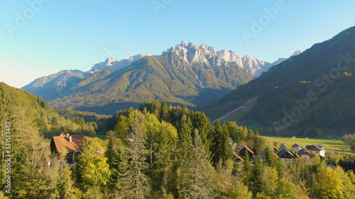 DRONE: Scenic view of idyllic countryside under a towering mountain in Slovenia.