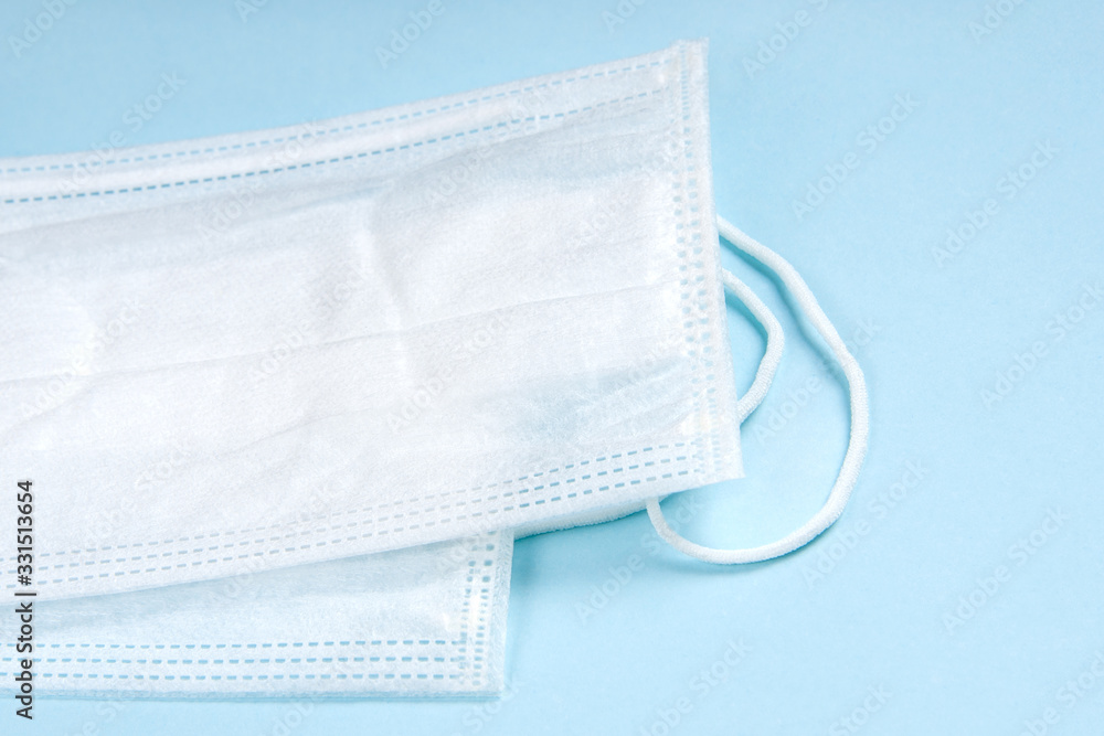 Medical masks lie on a table on a blue background. Сoncept novel coronavirus 2019-nCoV. Chinese coronavirus outbreak Medical masks lie on a table on a blue background. Сoncept novel coronavirus 2019-nCoV. Chinese coronavirus outbreak