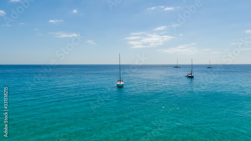 Aerial view on boat on turquoise water sea. Top view on yacht, Fuerteventura Spain 