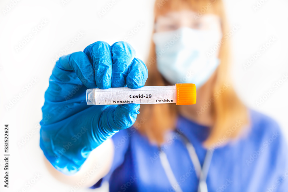 eine Ärztin hält ein Abstrichröhrchen mit Coronavirus in der Hand eine Ärztin hält ein Abstrichröhrchen mit Coronavirus in der Hand