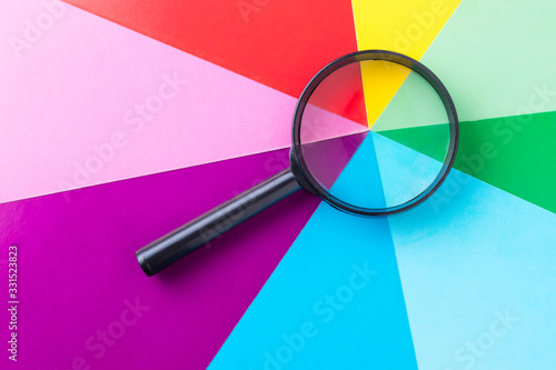 Fotografie, Tablou Magnifying glass on multi-colored sheets of paper