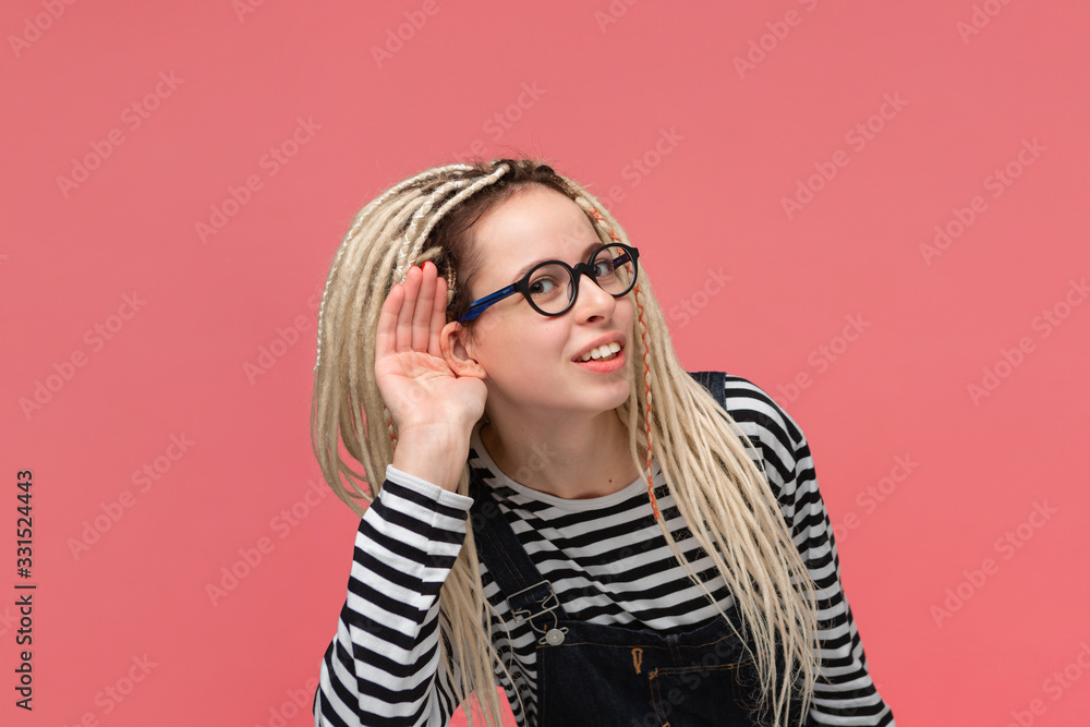 Young woman bending forward holding hand close to ear to hear important information. Young woman bending forward holding hand close to ear to hear important information.
