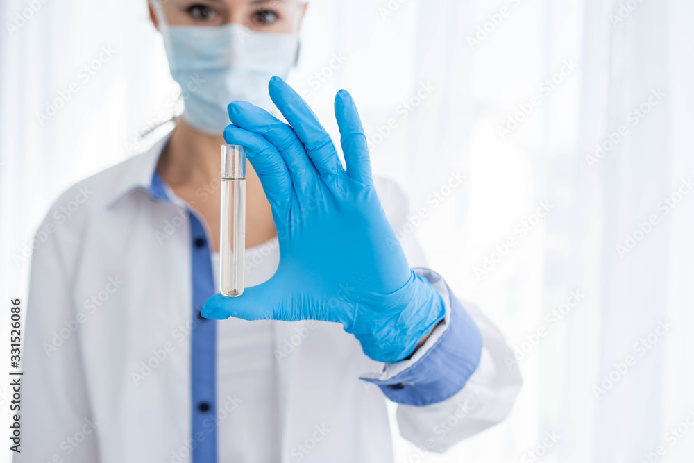 Female doctor or nurse in medical mask holding syringe with injection Female doctor or nurse in medical mask holding syringe with injection