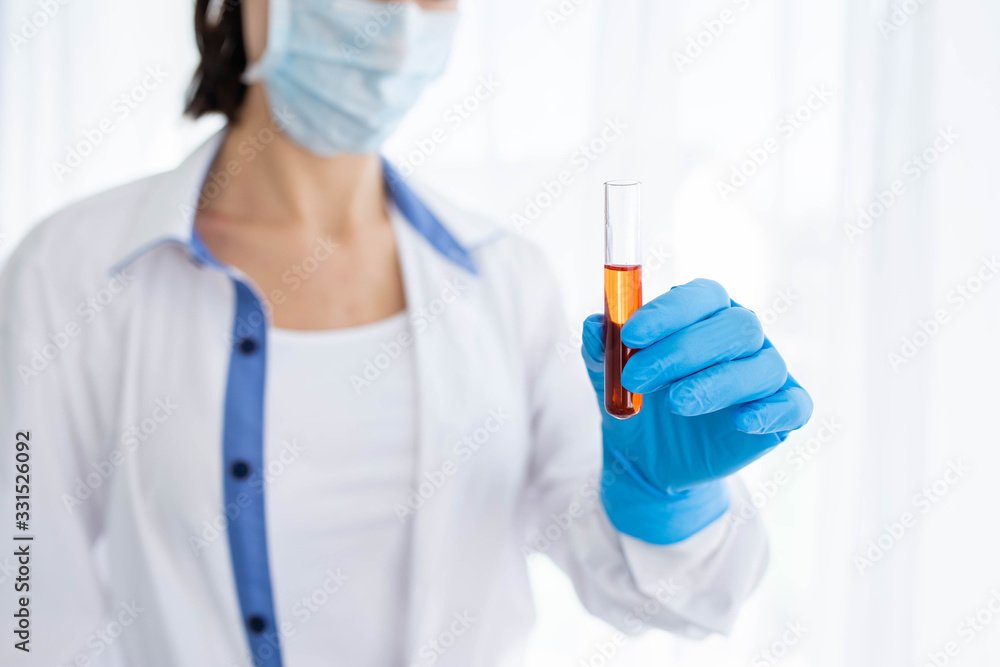 Female doctor or nurse in medical mask holding syringe with injection Female doctor or nurse in medical mask holding syringe with injection