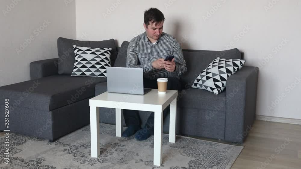 man using mobile phone while working on computer at home man using mobile phone while working on computer at home