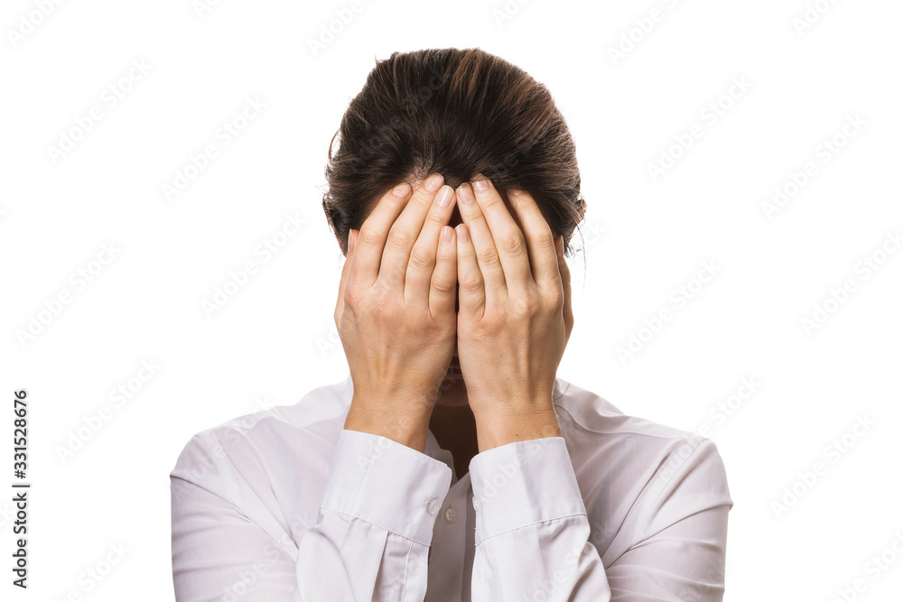 Girl in a shirt covered her face with hands isolated on a white background Girl in a shirt covered her face with hands isolated on a white background